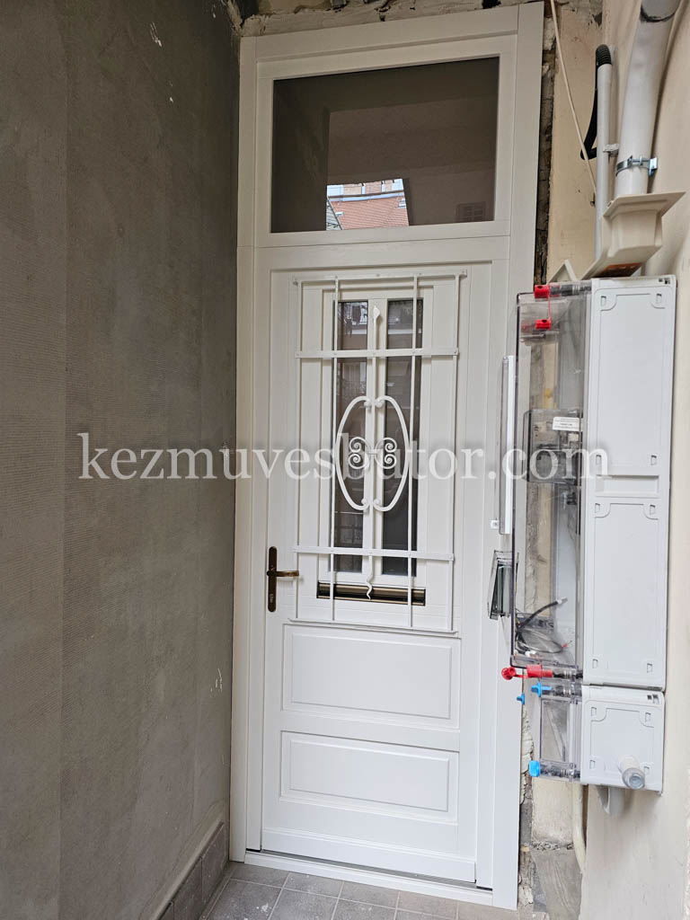 Belvárosi fehér bejárati ajtó vasráccsal és ablakkal Fehér bejárati ajtó kis ablakkal és díszes vasráccsal belvárosi épületben